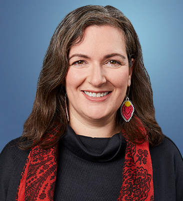 A portrait-style photograph of Caitlin Burley wearing a red scarf and black shirt.