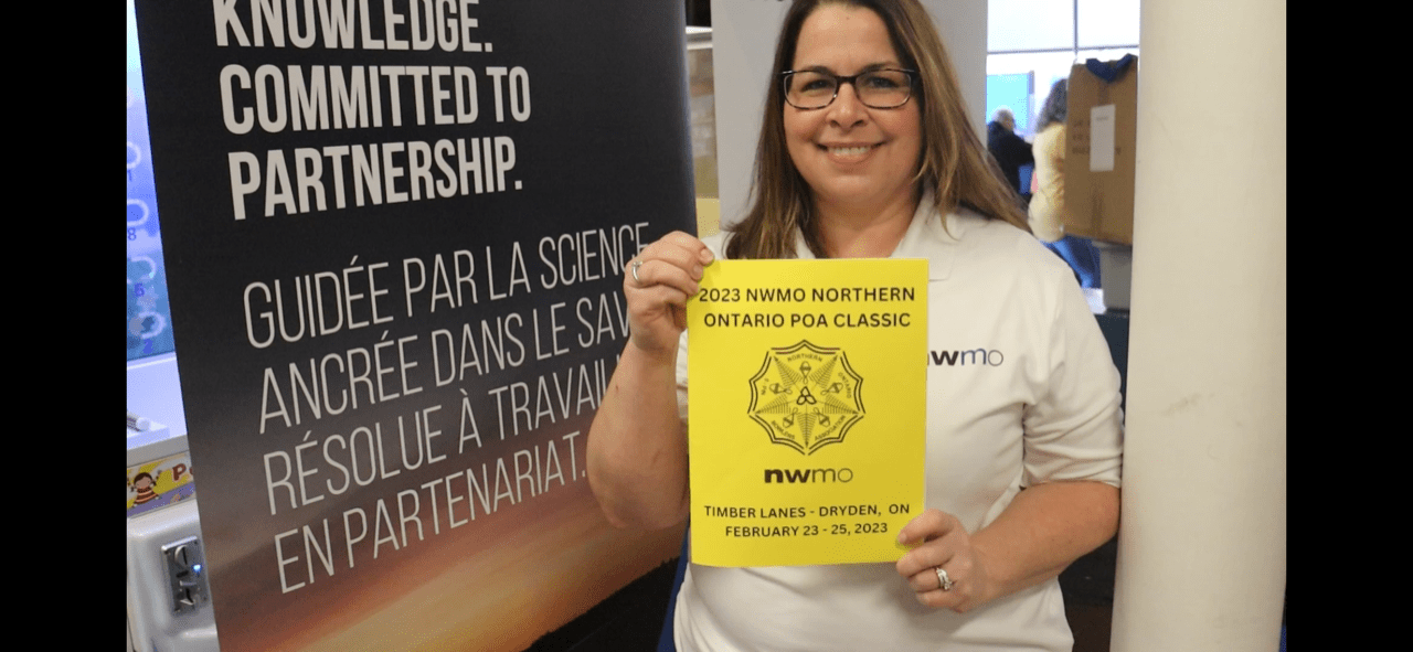 An NWMO employee holds up a sign showing the NWMO's support of 5 pin bowling.