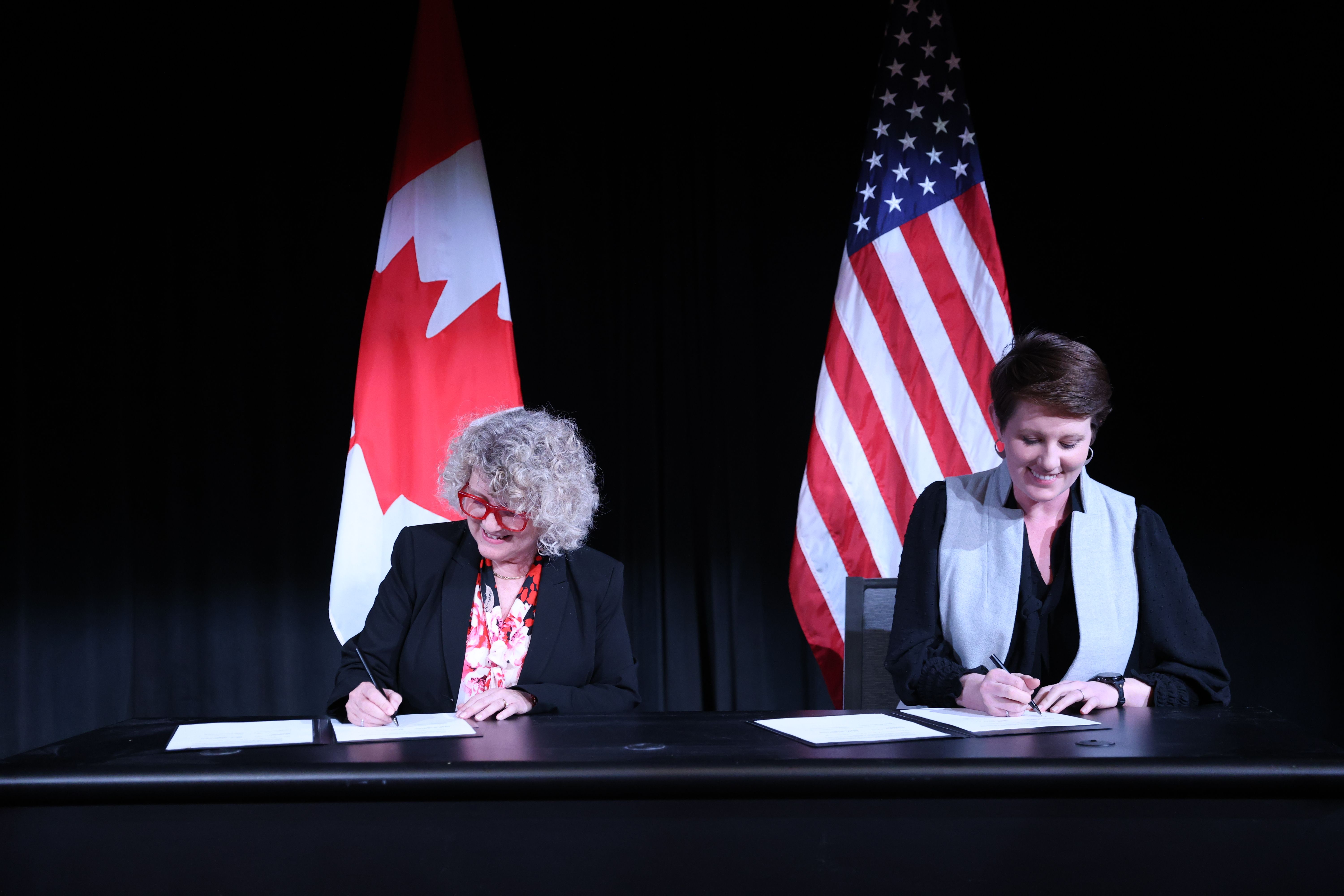 At Canada’s Embassy in Washington, Laurie Swami, President and CEO of the Nuclear Waste Management Organization (left) and Dr. Kathryn Huff, Assistant Secretary for Nuclear Energy at the U.S. Department of Energy (right), sign a Statement of Intent to Co-operate on Used Nuclear Fuel Management.