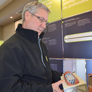Larry McCabe, Chief Administrative Officer of the Town of Goderich, examines a model of a used fuel container.
