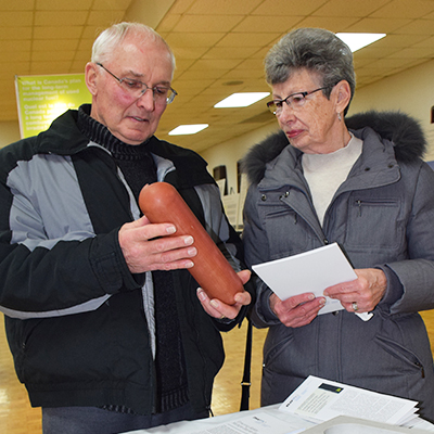 This image shows two South Bruce community members looking at the new used fuel container model at the open house.