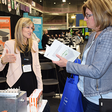 This picture shows a delegate at our booth in conversation with the NWMO's Jessica Gosbee.