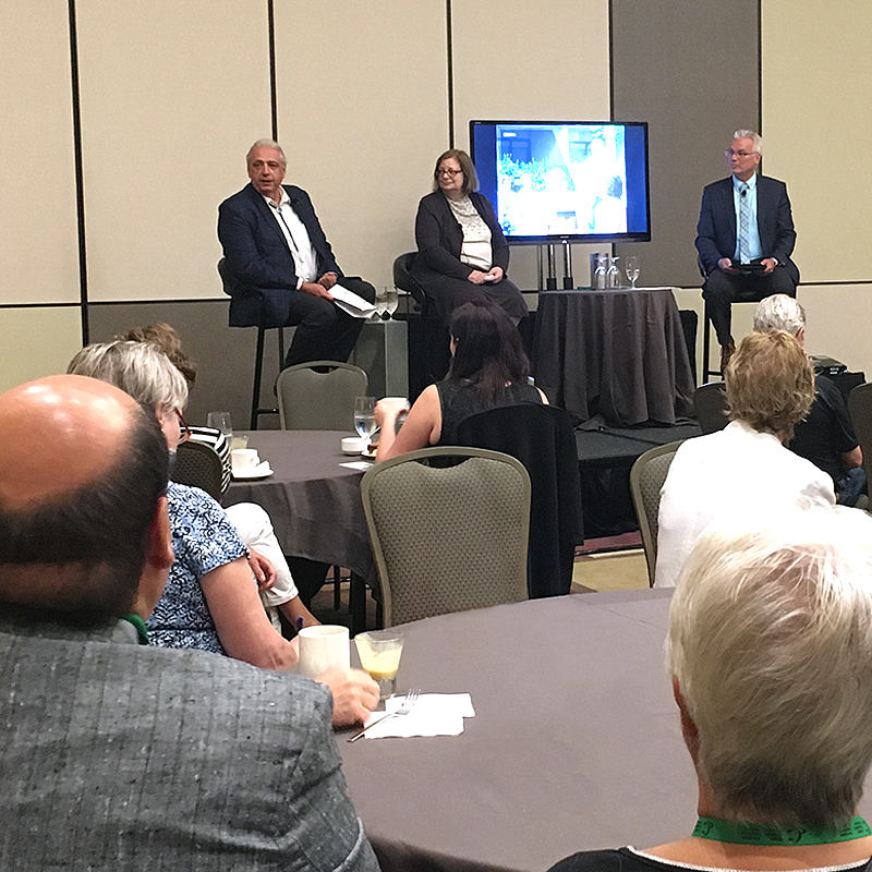 Three people have a conversation on stage