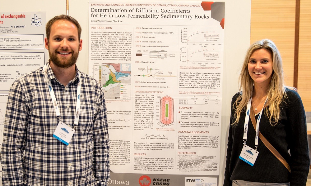 This image shows two students in front of their poster.