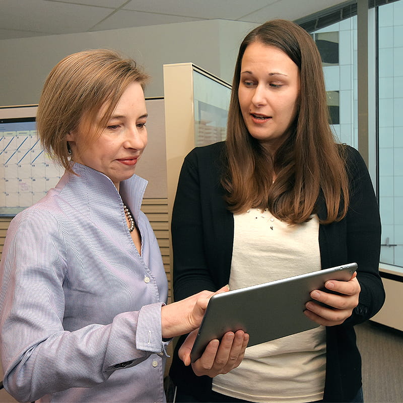 This is a picture of two people looking at the website on a tablet
