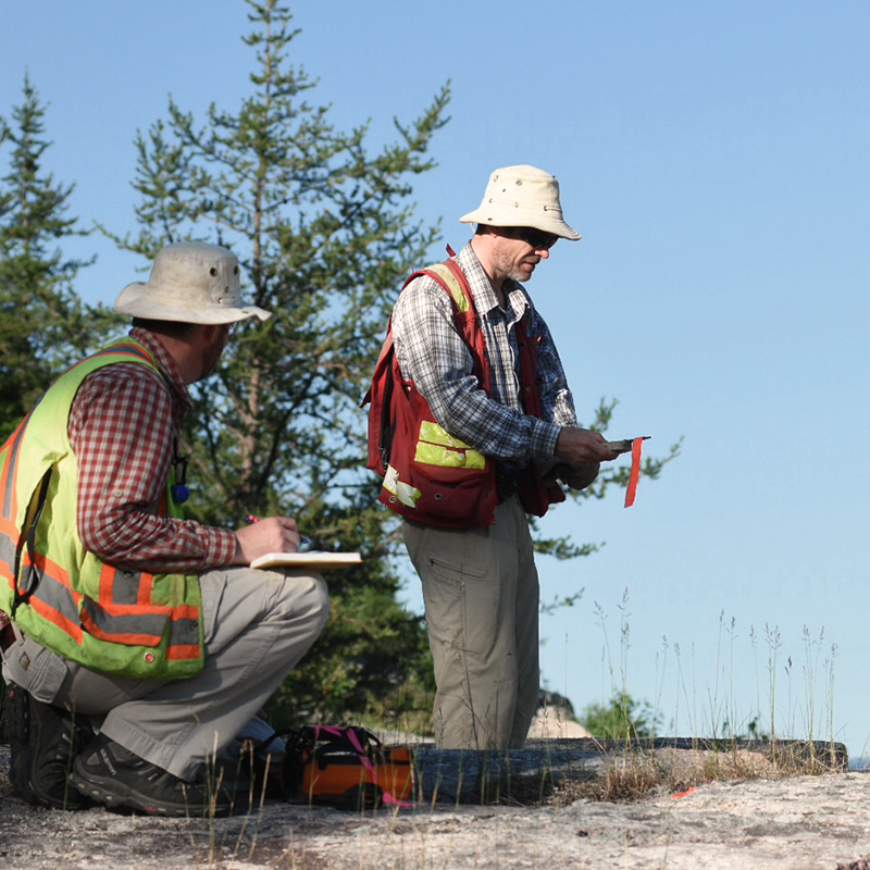 Two geologists studying areas of interest in Northern Ontario
