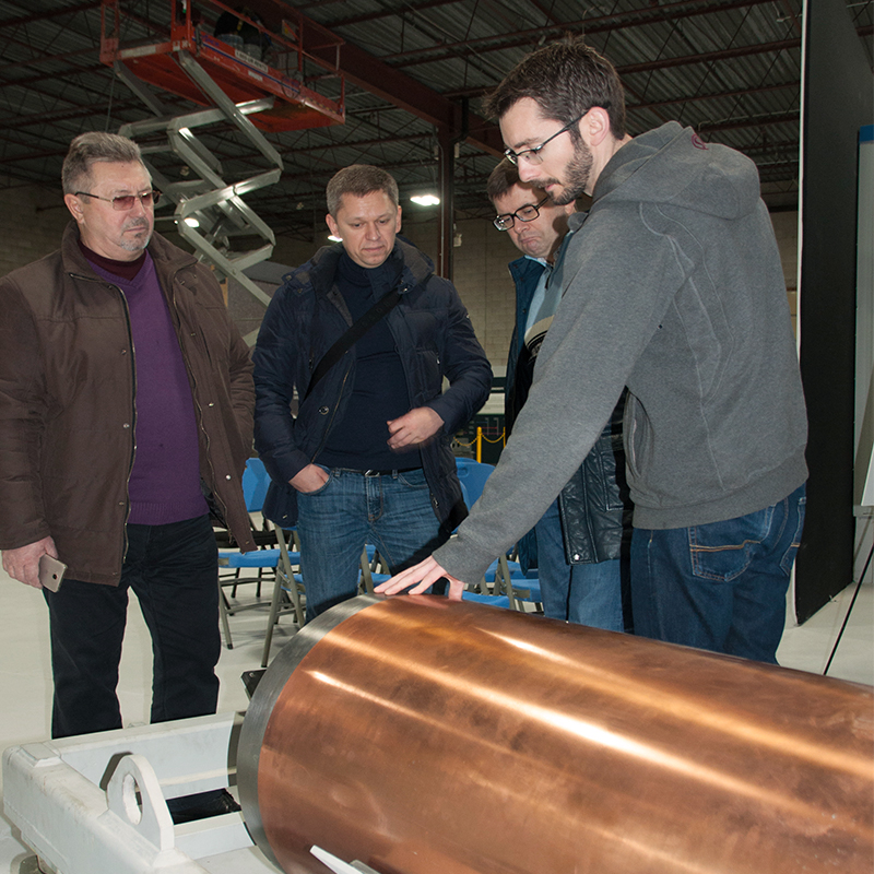 Trois membres de la délégation ukrainienne examinent un conteneur de combustible nucléaire irradié à l’installation d’essais de sûreté d’Oakville.