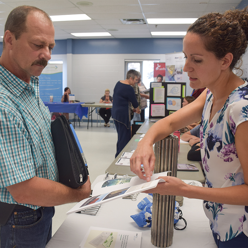 Cette photo illustre un résident local parlant avec Cherie Leslie de la SGDN au kiosque de la SGDN
