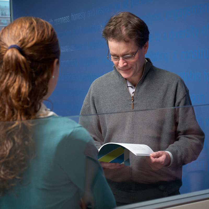 An employee of the NWMO looks at the annual update of the document, Implementing Adaptive Phased Management.
