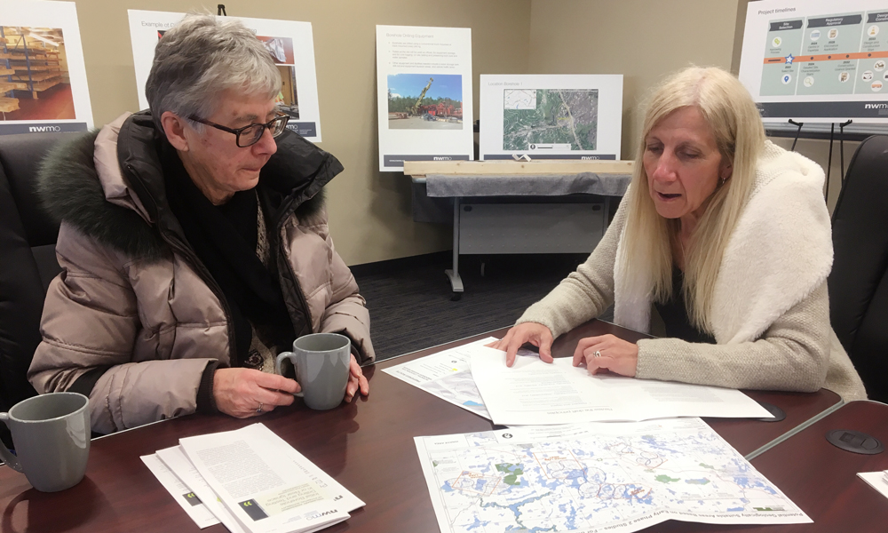 La photo montre deux femmes qui examinent des cartes, assisses à une table.