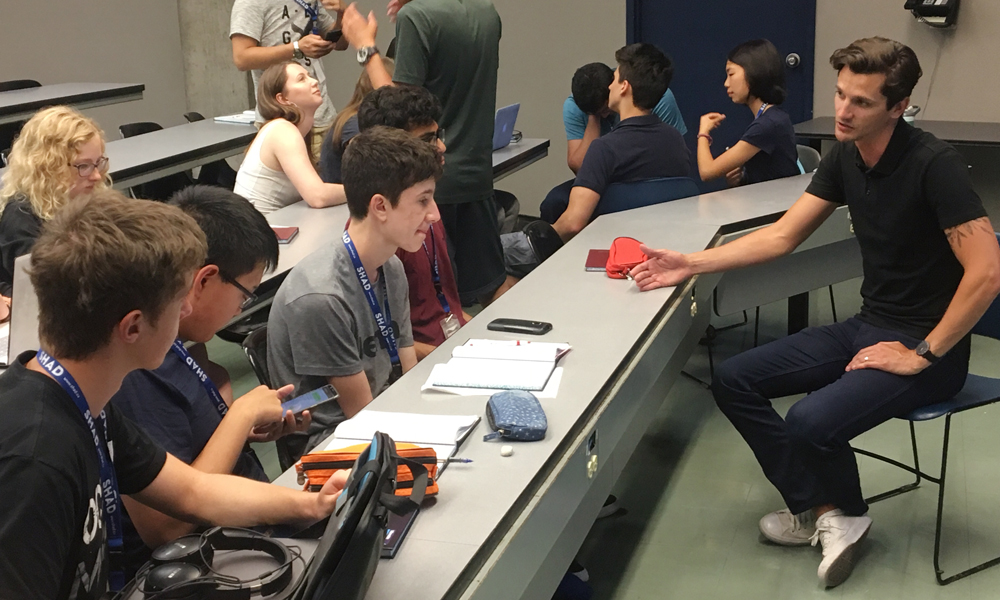 Image montrant des élèves dans une salle de classe écoutant un spécialiste dans un cadre informel. 