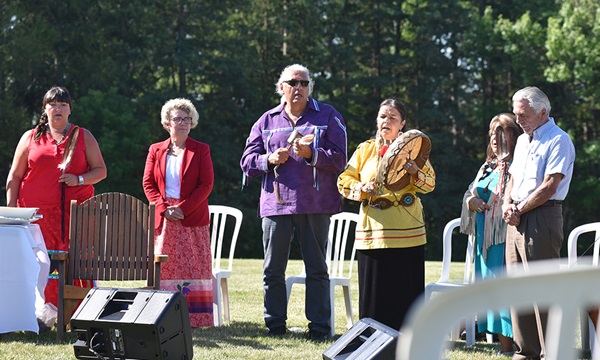 La photo montre six personnes participant à une cérémonie de tambour autochtone.