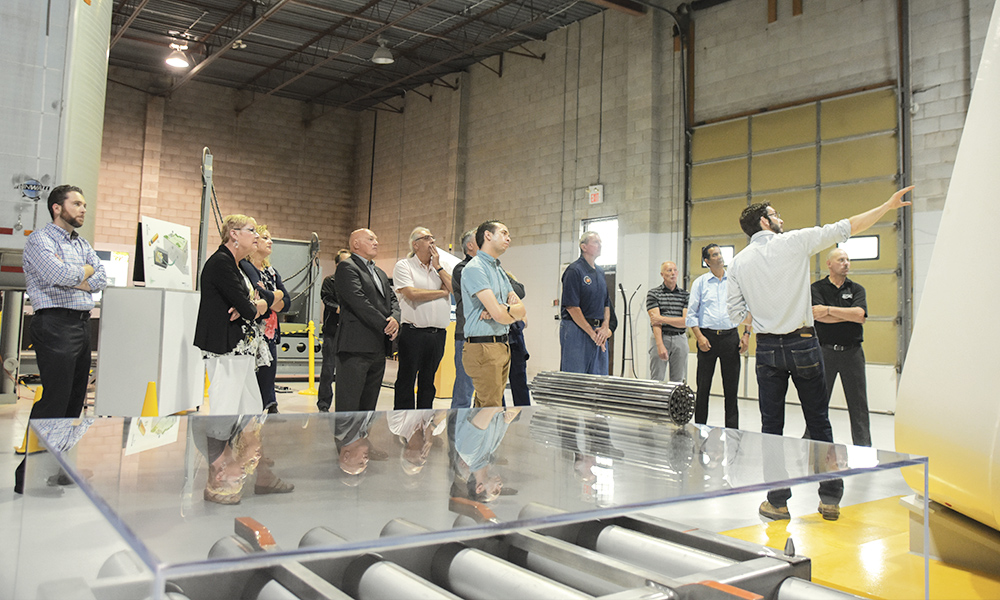 Photo shows several people looking at an installation at the NWMO's Proof Test Facility. 