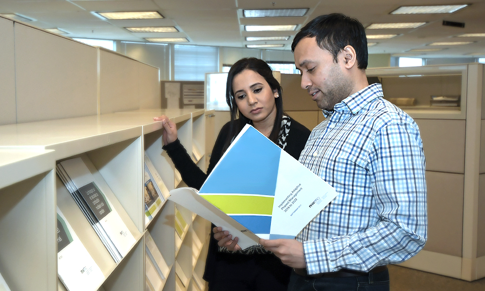 Image shows two people reading the implementation plan. 