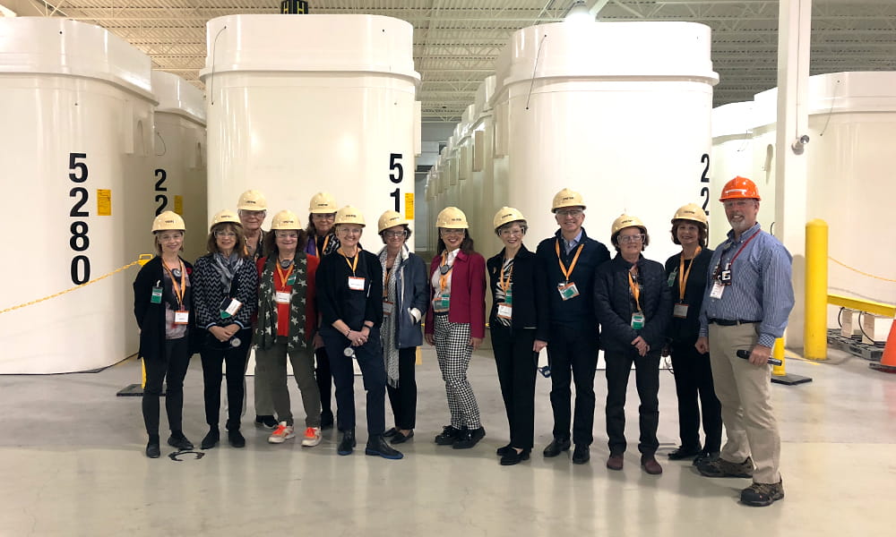 Cette photo montre un groupe de personnes devant des conteneurs de stockage à sec.