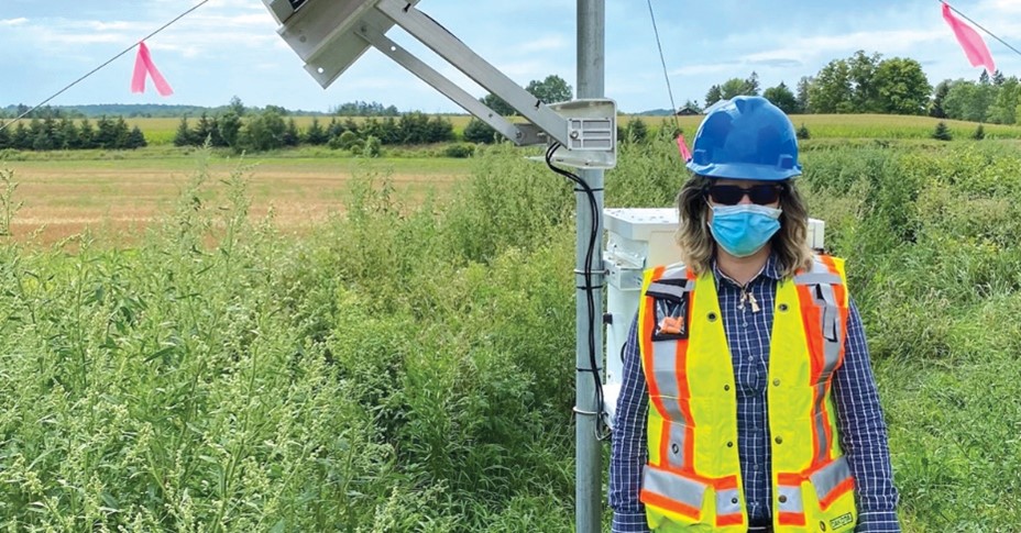 A NWMO employee standing in a sunny field.