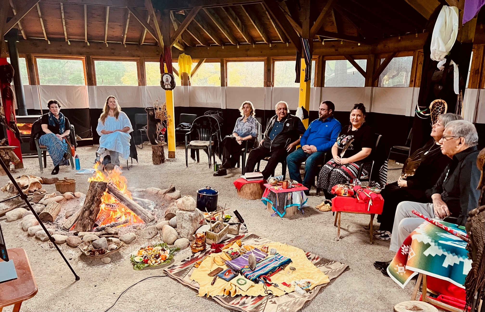 People gathered in a circle around a fire.