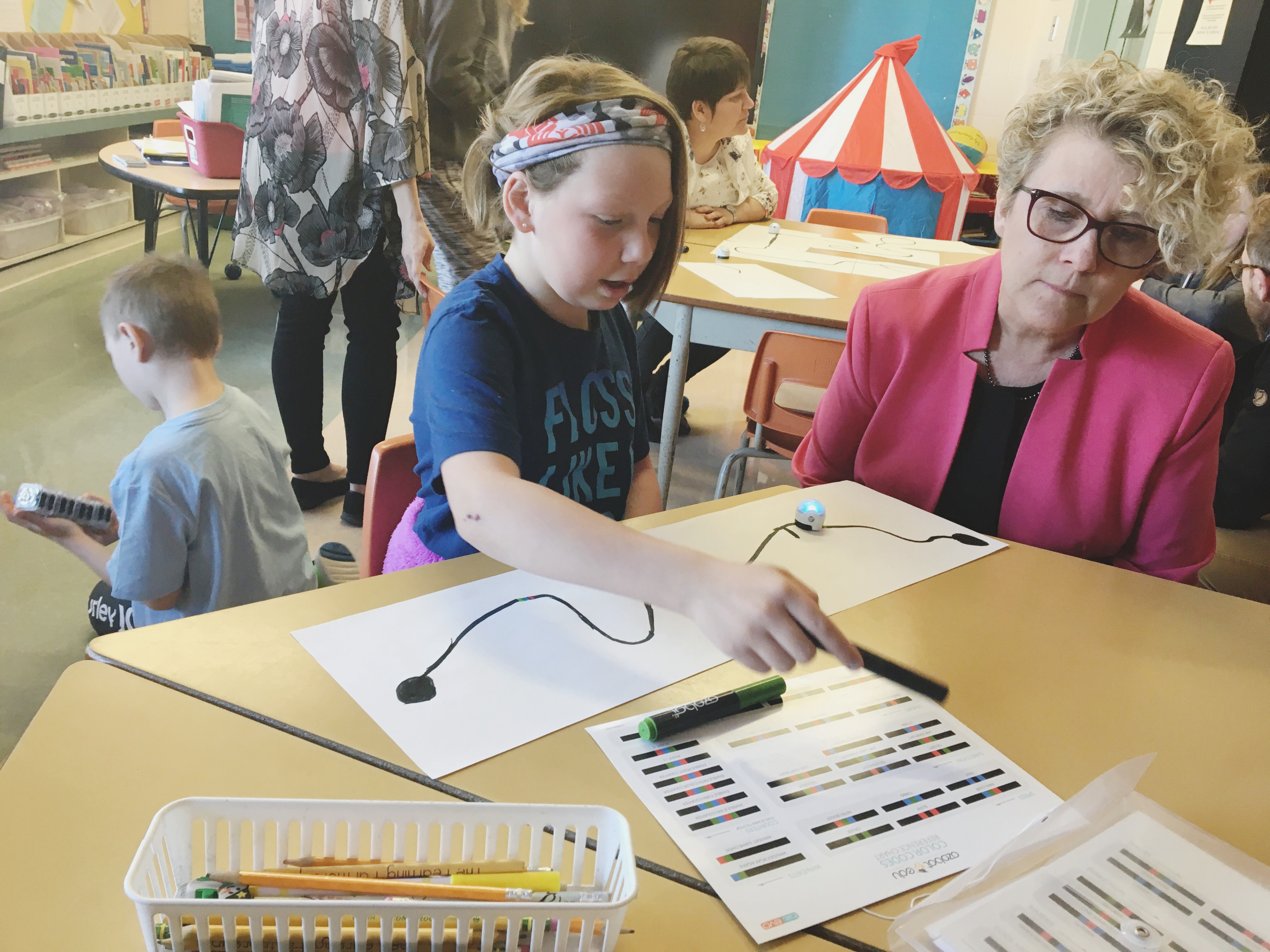 NWMO President and CEO Laurie Swami watches a student from the Holy Name of Jesus Catholic School in Hornepayne share what she has learned from working with a robotics kit.