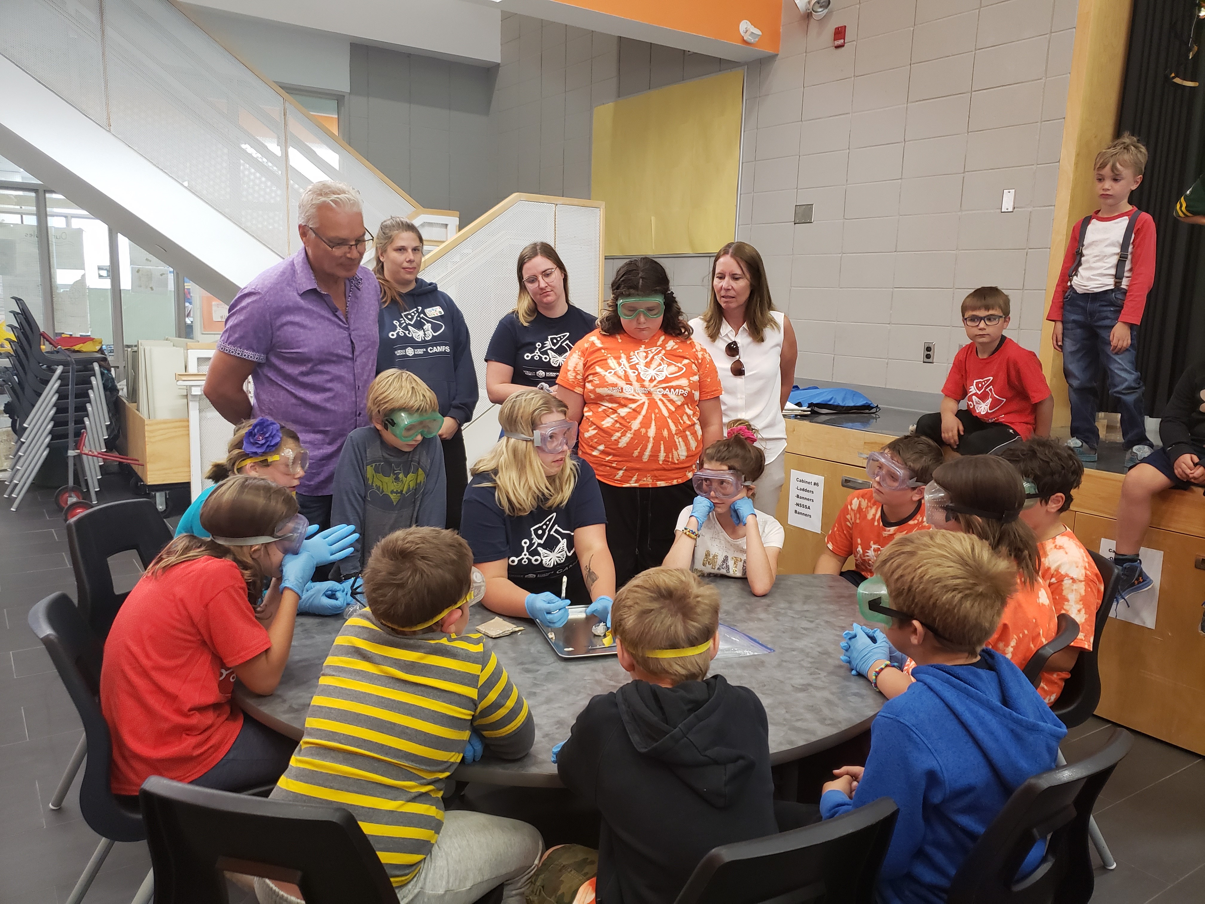 Norman Sandberg, NWMO Relationship Manager, and Carol Barnes, NWMO Community Liaison Manager, along with campers, watch a Science North staff member conduct a science demonstration.